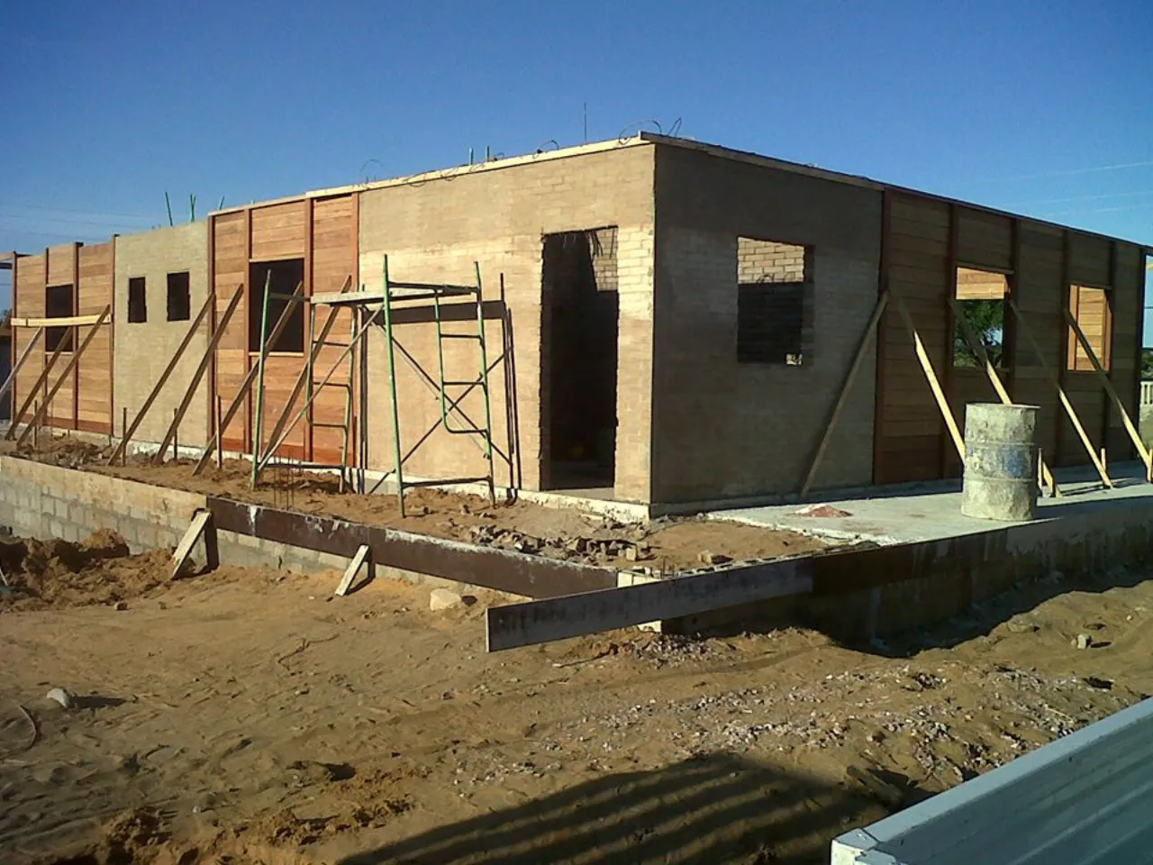 Casa em construção com paredes de tijolo ecológico e painéis de madeira, na África do Sul